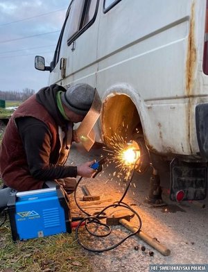 Mężczyzna podczas spawania uszkodzonego elementu koła