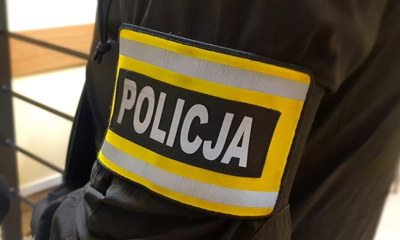 Opaska z napisem policja na rękawie policjanta