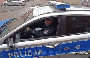 policjant siedzi na miejscu kierowcy w radiowozie