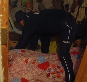 Policjantka okrywa kołdrą starszą kobietę