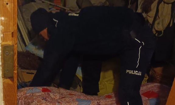 Policjantka okrywa kołdrą starszą kobietę