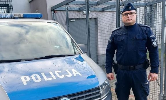 Przy radiowozie stoi policjant