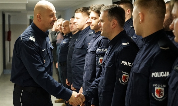 komendant wojewódzki Policji w Bydgoszczy wita się z policjantami stojącymi  w szeregu na korytarzu w Komendzie Miejskiej Policji we Włocławku