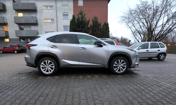 Pojazd marki Lexus na tle budynków