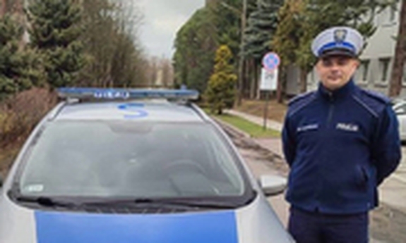 policjant stoi przy radiowozie