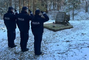 policjanci przy obelisku w miejscu katastrofy śmiglowca