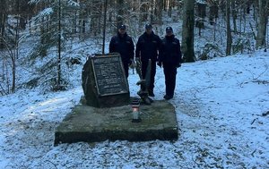 policjanci przy obelisku w miejscu katastrofy śmiglowca