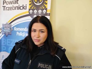 umundurowana policjantka stoi przy policyjnym banerze