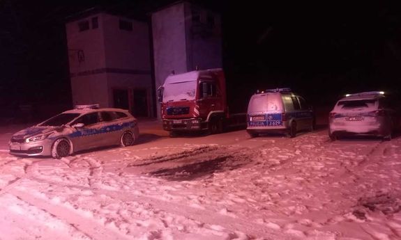 Ś9nieg na drodze. Obok stoją radiowozy i wóz strażacki