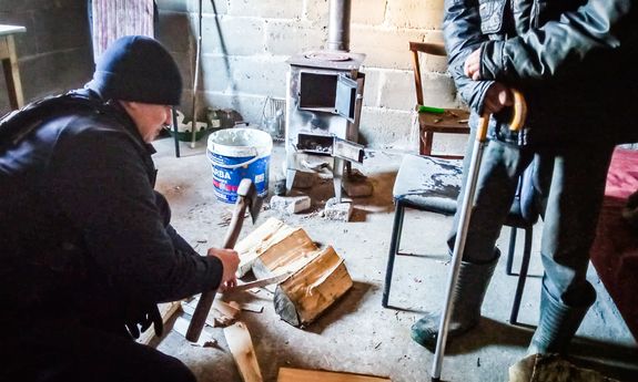 Policjanci pomagają potrzebującemu mężczyźnie , rąbią drzewo.