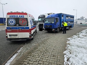 karetka stoi przy dwóch ciężarówkach