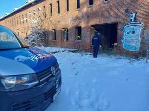 umundurowany policjant w trakcie patrolu pustostanu