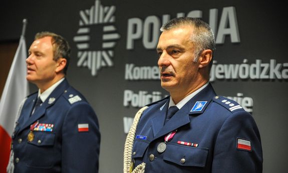 Dwóch policjantów stoi na sali konferencyjnej