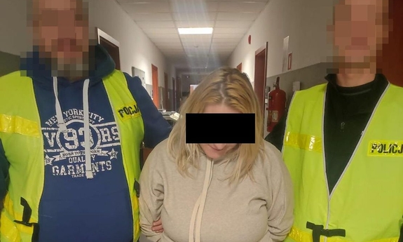 dwóch policjantów prowadzi zatrzymaną kobietę