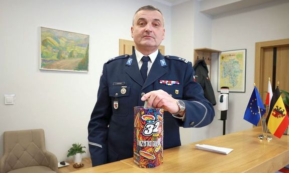 Policjant wrzuca pieniądze do puszki WOŚP