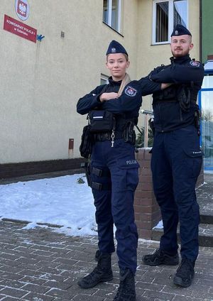 umundurowana policjantka i policjant stoją przy radiowozie