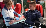 policjant podczas oddawania krwi, przy nim pielęgniarka