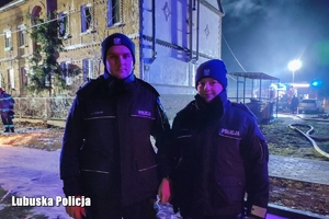 Policjant i policjantka, w tle budynek.