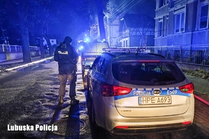 Policjant przy radiowozie policyjnym.