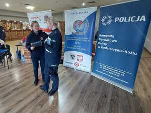 Zdjęcie przedstawia policjantkę rozdającą ulotki
