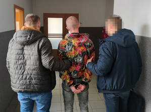 Dwaj nieumundurowani policjanci z zatrzymanym mężczyzną