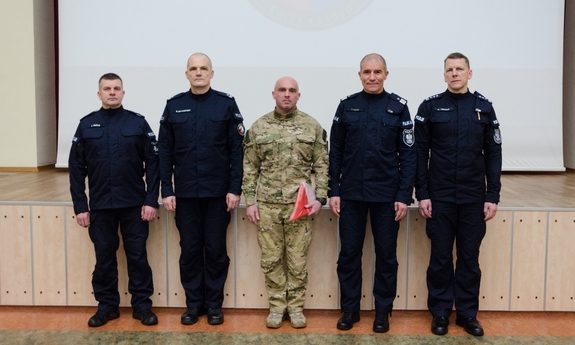 Zastępca Komendanta Głównego Policji nadinsp. Roman Kuster, obok niego stoi Komendant Szkoły Policji w Słupsku oraz policjant z JSPP, który otrzymał flagę Polski i dwaj inni policjanci.