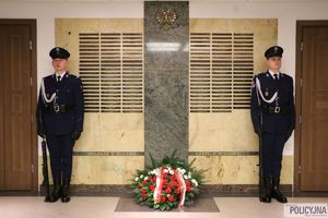 Policjanci przy tablicy pamiątkowej.