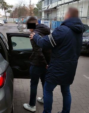 Policjant każe zatrzymanemu wsiąść do radiowozu