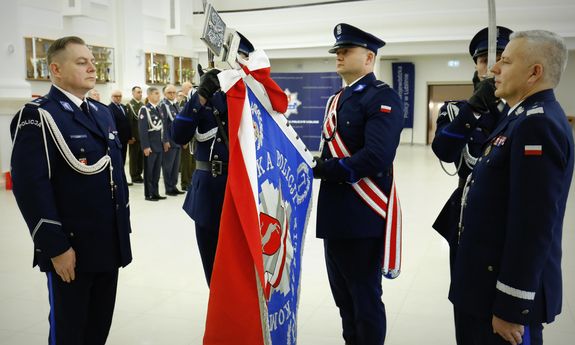 Komendant stoi przed sztandarem