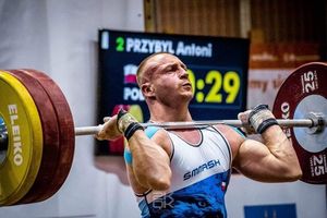 Mężczyzna podnosi sztangę