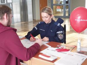 Policjantka podpisuje dokumenty z dawcą szpiku