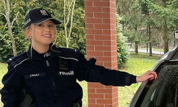Policjantka stoi przy radiowozie
