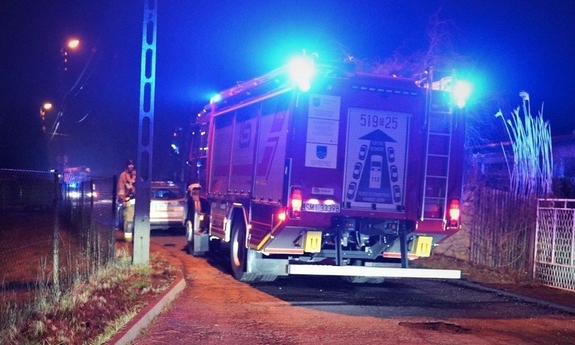 pora nocna, wóz straży pożarnej oraz Policji, z lewej dom