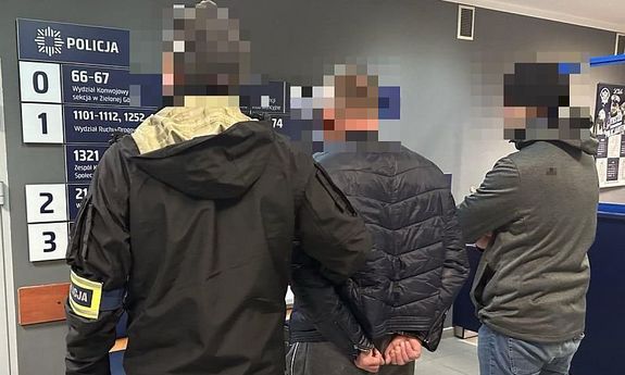 Policjanci stoją z zatrzymanym