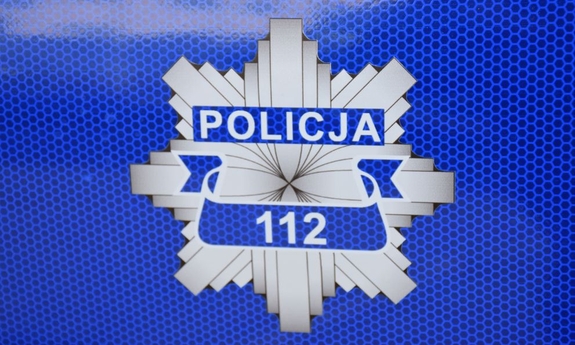 Gwiazda policyjna z napisem Policja 112 na drzwiach radiowozu policyjnego