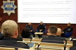 trzej policjanci siedzą na fotelach na scenie podczas forum