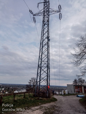 Słup energetyczny na którym stoi mężczyzna