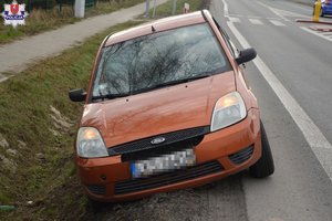 osobowy ford stoi częściowo na poboczu a częściowo w przydrożnym rowie