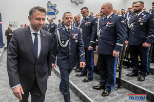 Komendant Główny Policji idzie z Ministrem Spraw Wewnętrznych i Administracji. Obok stoją zaproszeni policjanci