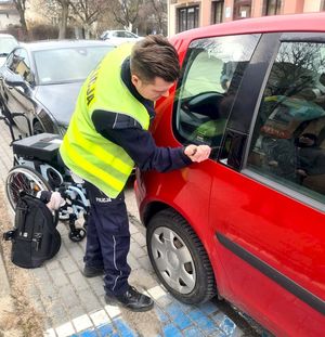 Policjant wybija szybę w pojeździe