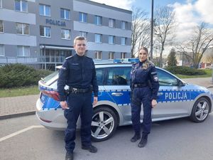 Policjanci stoją przy radiowozie