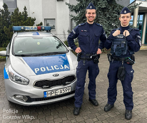 Policjanci stoją przy radiowozie