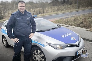 policjant stojący przy radiowozie