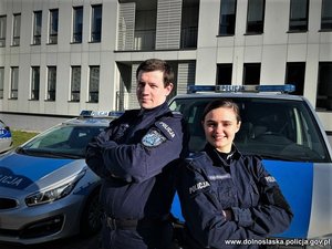 Policjant i policjantka przy radiowozie