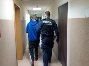 policjant prowadzi zatrzymanego