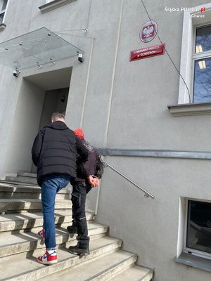 policjant prowadzi zatrzymanego