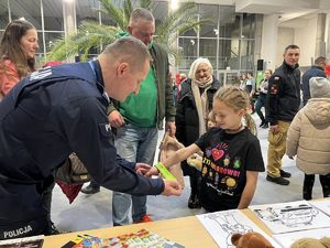 policjant daje dziewczynce gadżety policyjne