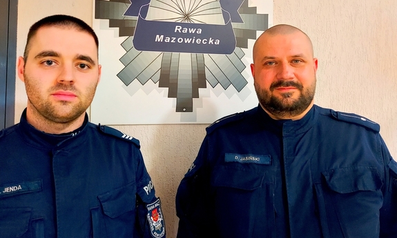 Dwóch policjantów, na ścianie gwiazda policyjna z napisem policja Rawa Mazowiecka