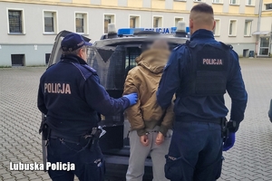 Policjanci prowadzą zatrzymanego