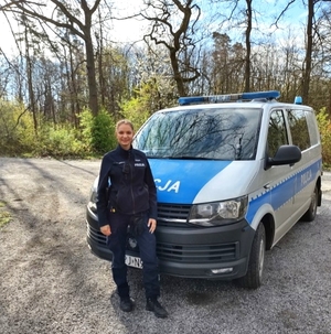 policjantka stoi przy radiowozie policyjnym